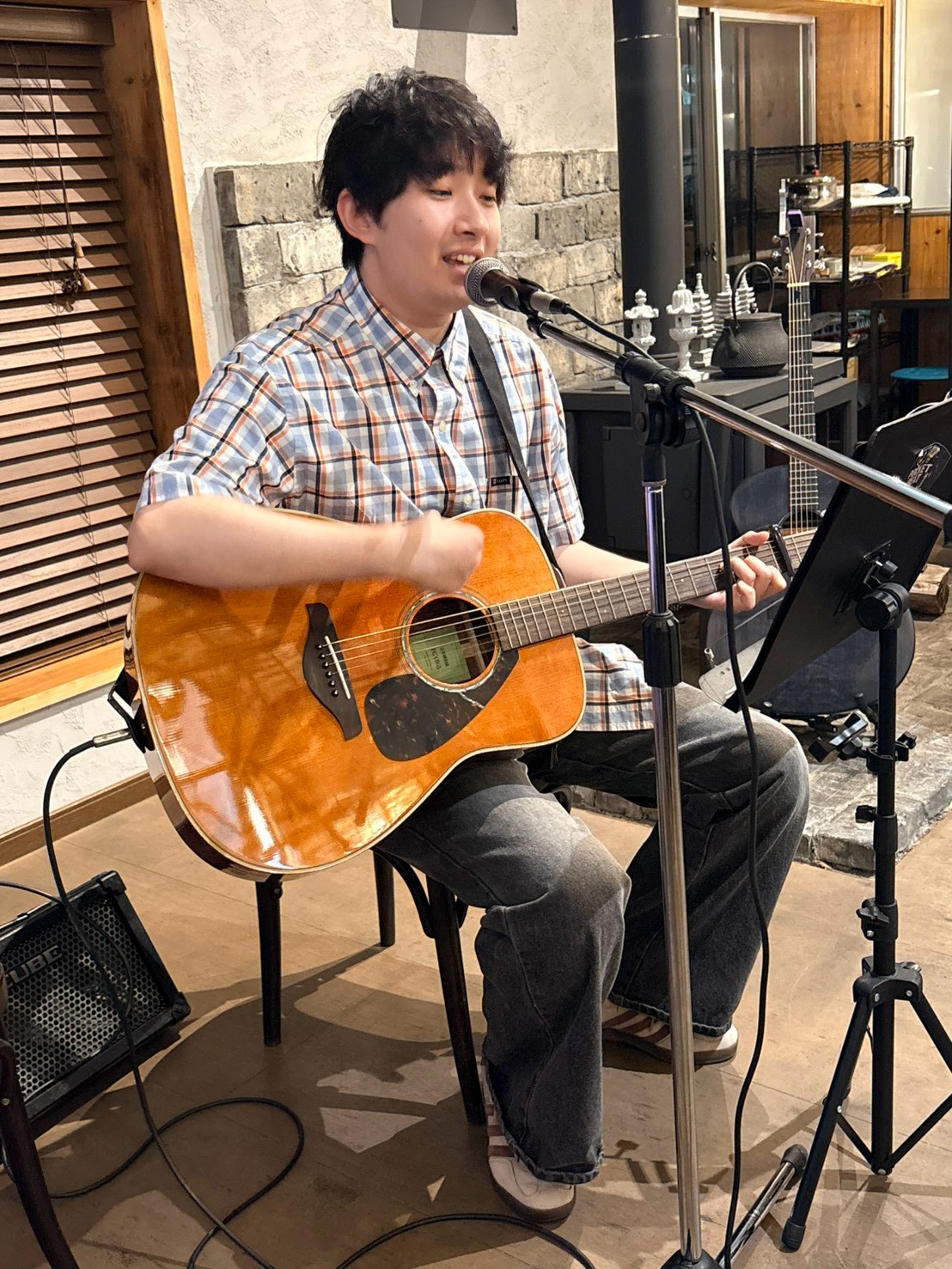 笑顔でギターを弾き語る生徒さん